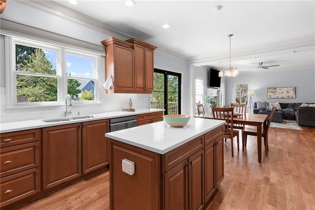 kitchen featuring decorative backsplash, brown cabinetry, light wood-type flooring, a sink, and light countertops