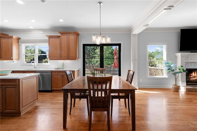 dining space with plenty of natural light, light wood-type flooring, and a notable chandelier