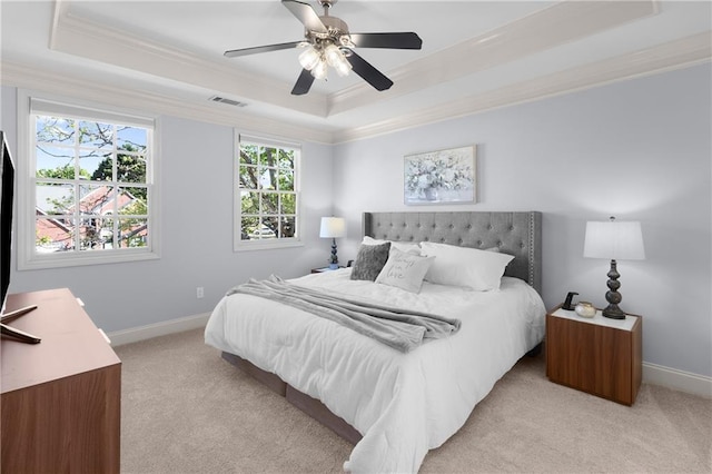 bedroom with light carpet, a raised ceiling, baseboards, visible vents, and ornamental molding