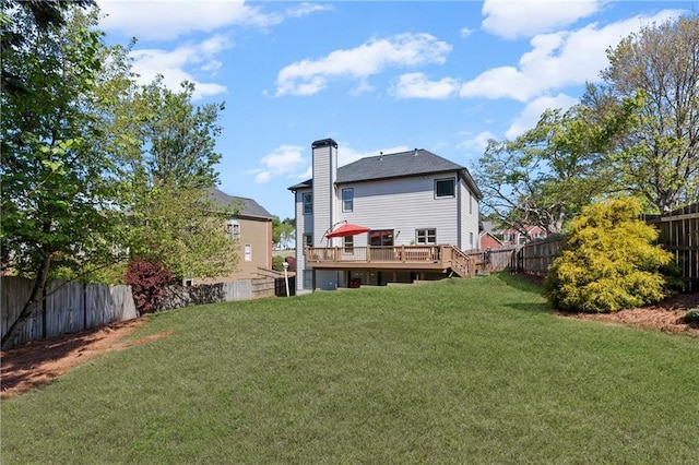 back of house featuring a fenced backyard, a lawn, and a deck