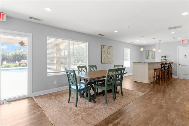dining area featuring visible vents, baseboards, and wood finished floors