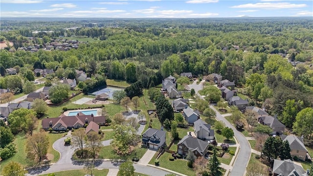 birds eye view of property featuring a residential view and a wooded view