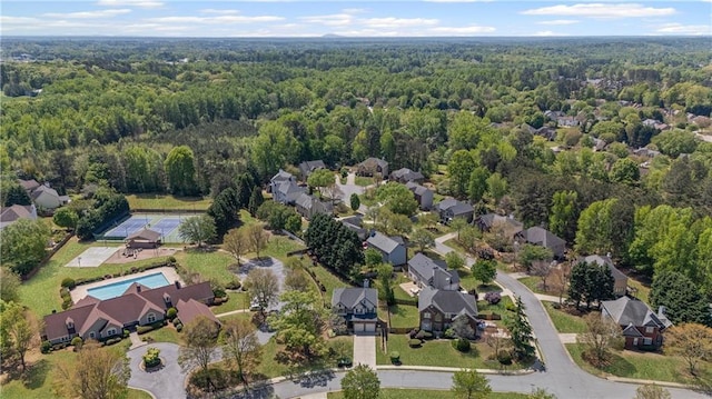 drone / aerial view featuring a residential view and a wooded view