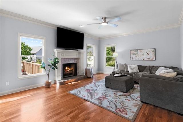 living area with ceiling fan, a healthy amount of sunlight, and wood finished floors