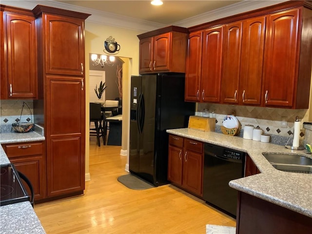1162 Mason Lee, Loganville, GA 30052 - kitchen with light wood finished floors, a sink, dark brown cabinets, crown molding, and black appliances