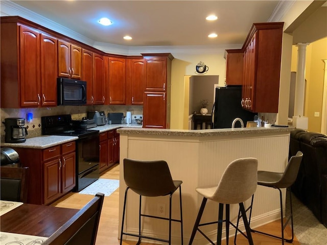 1162 Mason Lee, Loganville, GA 30052 - kitchen with a peninsula, a kitchen breakfast bar, decorative columns, and black appliances