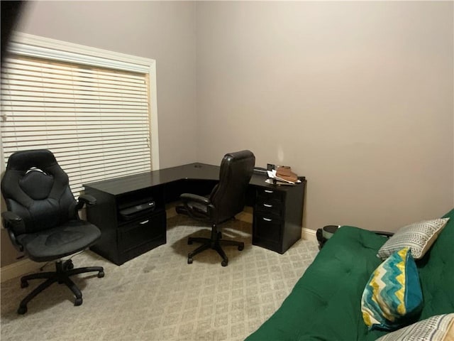 home office with baseboards and light colored carpet