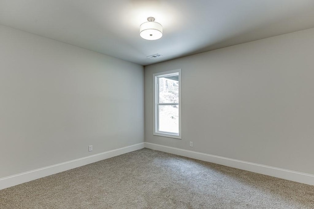 unfurnished room featuring carpet, visible vents, and baseboards