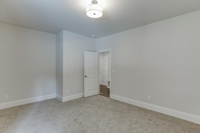 empty room with baseboards and light colored carpet