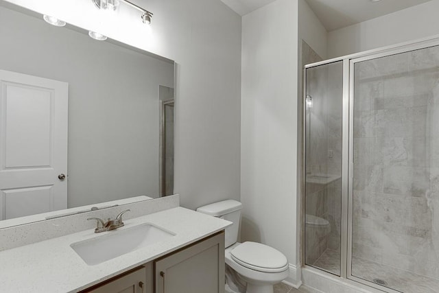 bathroom with a stall shower, vanity, and toilet