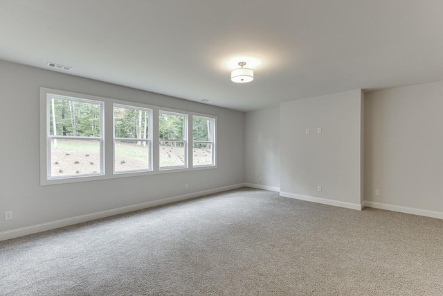 empty room with light carpet, visible vents, and baseboards