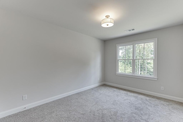 unfurnished room featuring baseboards, visible vents, and carpet flooring