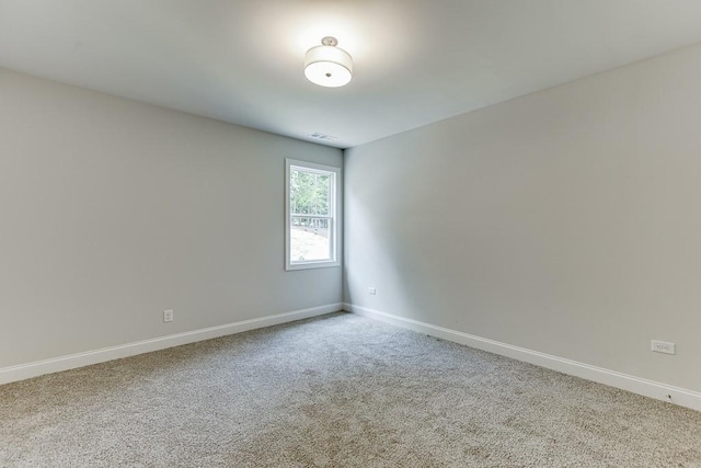 carpeted spare room featuring visible vents and baseboards