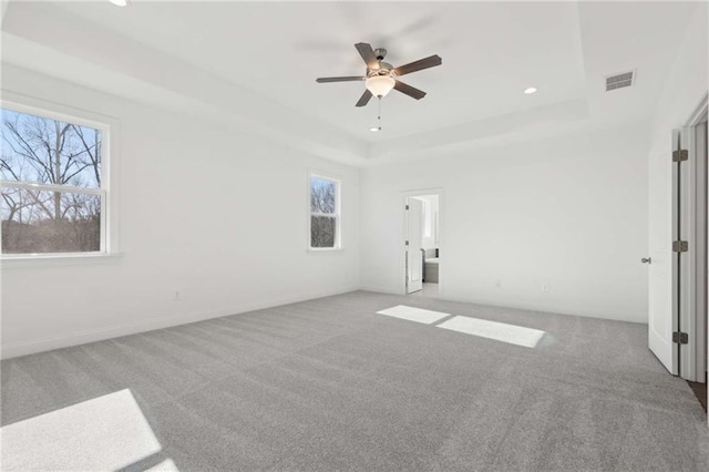 unfurnished bedroom featuring recessed lighting, a raised ceiling, visible vents, light carpet, and ceiling fan