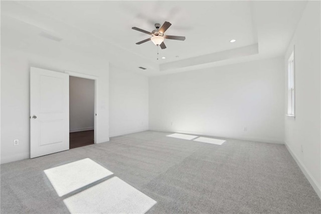 unfurnished bedroom featuring a ceiling fan, recessed lighting, a raised ceiling, and light colored carpet