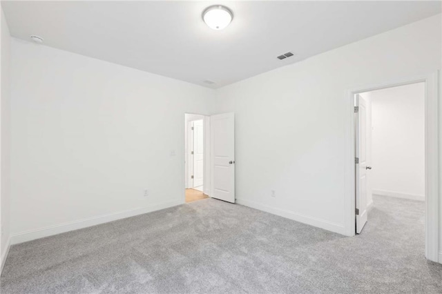 empty room with light carpet, baseboards, and visible vents