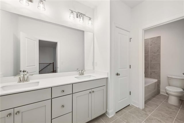 bathroom with tile patterned floors, a sink, toilet, and double vanity