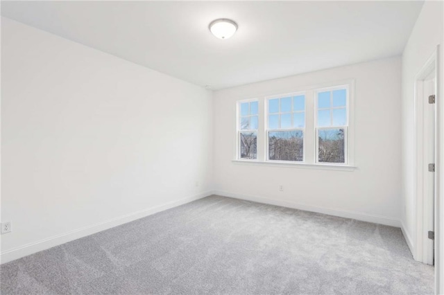 carpeted empty room featuring baseboards