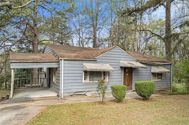 bungalow-style home with a front lawn and a carport