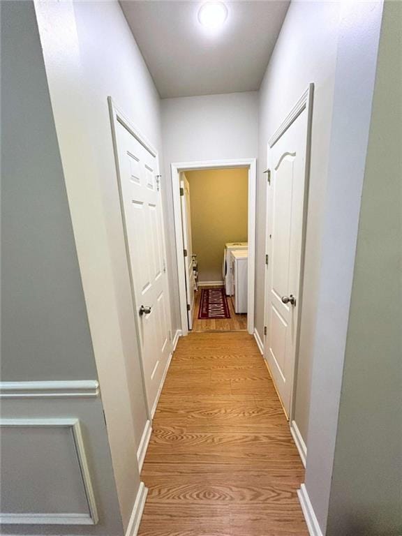 hallway featuring separate washer and dryer and light wood-style floors