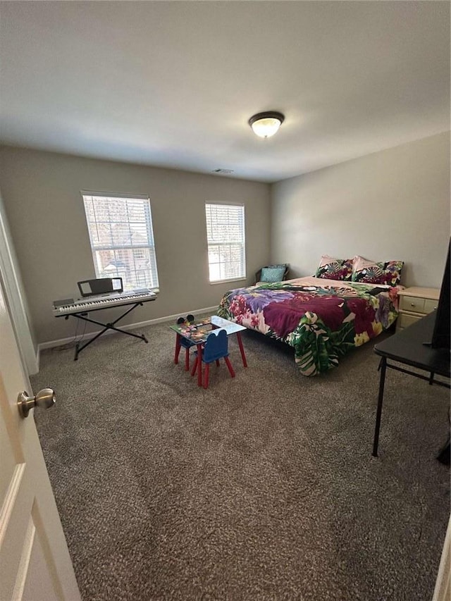 carpeted bedroom featuring visible vents and baseboards