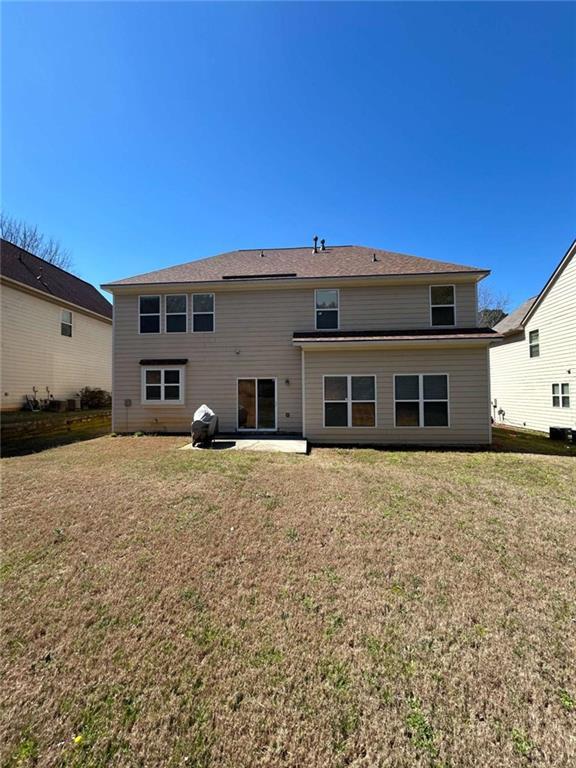 rear view of house featuring a yard