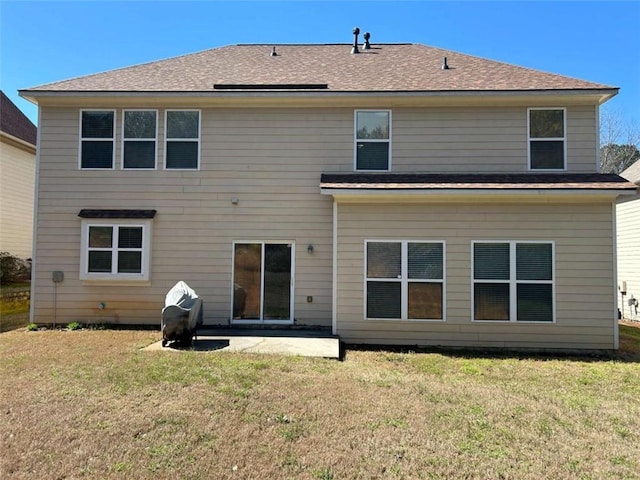 rear view of house featuring a lawn and a patio