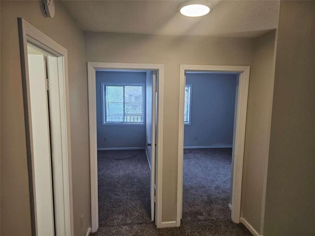 hallway featuring dark colored carpet