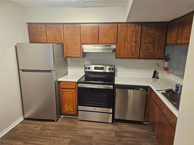 kitchen with stainless steel appliances, dark hardwood / wood-style floors, and sink