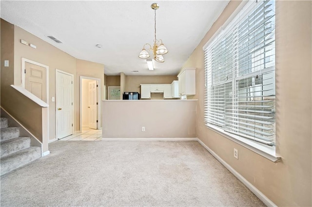 interior space with light colored carpet and a chandelier