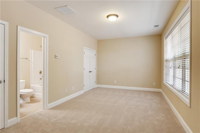 5060 Windcrest Ln, Alpharetta, GA 30022 - unfurnished bedroom with light carpet, multiple windows, and ensuite bathroom