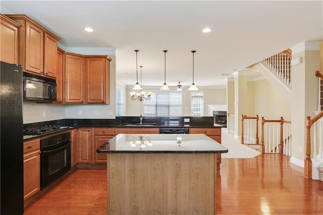 5060 Windcrest Ln, Alpharetta, GA 30022 - kitchen with black appliances, a peninsula, a center island, wood finished floors, and crown molding