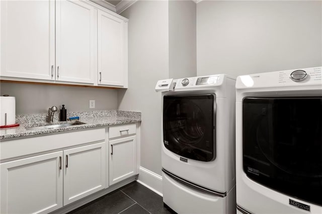 clothes washing area with dark tile patterned floors, washer and clothes dryer, sink, crown molding, and cabinets