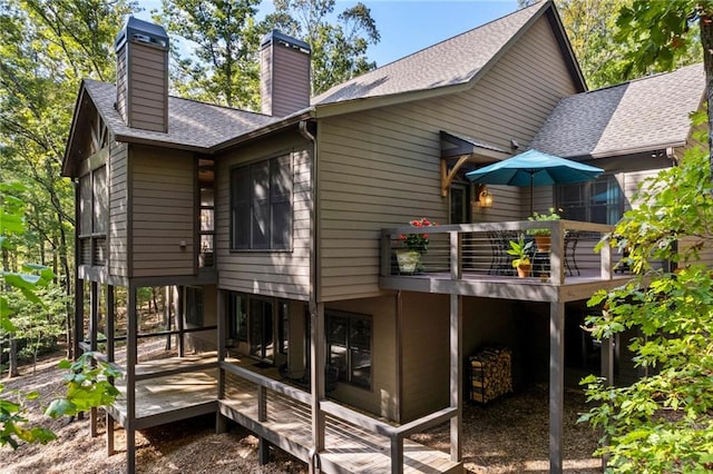 rear view of house featuring a wooden deck