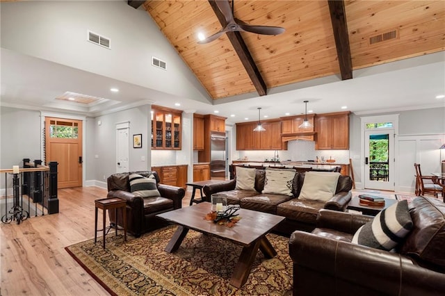 living room featuring high vaulted ceiling, ceiling fan, beamed ceiling, light hardwood / wood-style flooring, and ornamental molding