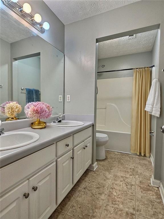 full bathroom with tile patterned floors, toilet, a textured ceiling, vanity, and shower / bath combo with shower curtain