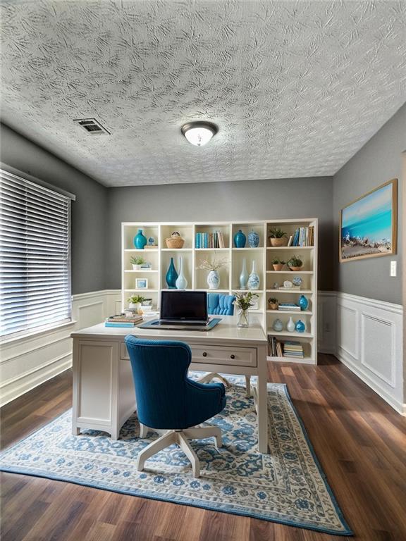 office featuring a textured ceiling and dark hardwood / wood-style flooring