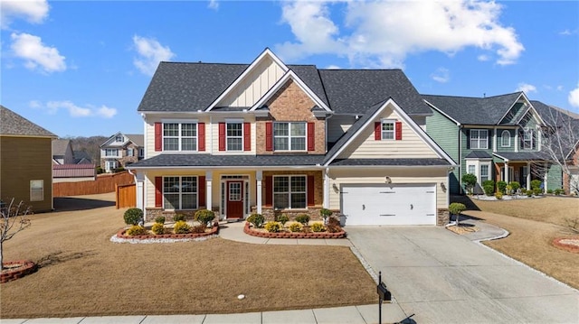 craftsman-style house with board and batten siding, stone siding, driveway, fence, and covered porch