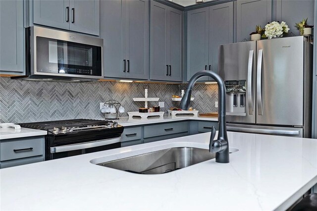 1433 Halpern Ln, Kennesaw, GA 30144 - kitchen featuring decorative backsplash, light countertops, appliances with stainless steel finishes, a sink, and gray cabinetry