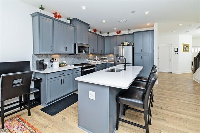 1433 Halpern Ln, Kennesaw, GA 30144 - kitchen with light countertops, a kitchen bar, appliances with stainless steel finishes, a sink, and backsplash