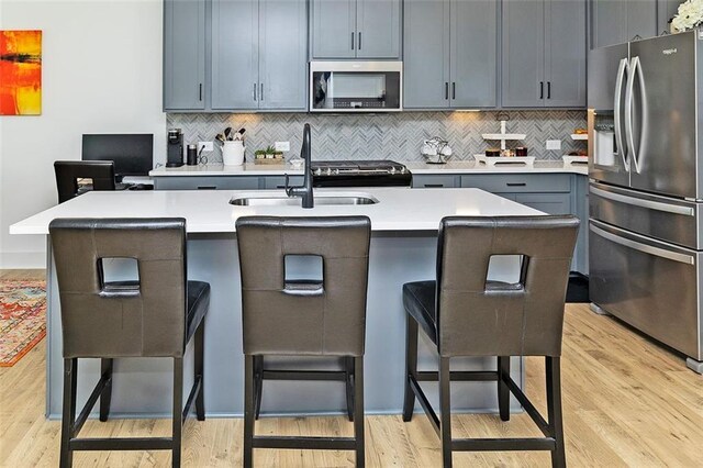 1433 Halpern Ln, Kennesaw, GA 30144 - kitchen featuring a kitchen breakfast bar, a sink, appliances with stainless steel finishes, and decorative backsplash