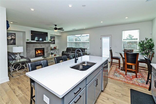 1433 Halpern Ln, Kennesaw, GA 30144 - kitchen with ceiling fan, a stone fireplace, a sink, gray cabinets, and stainless steel dishwasher