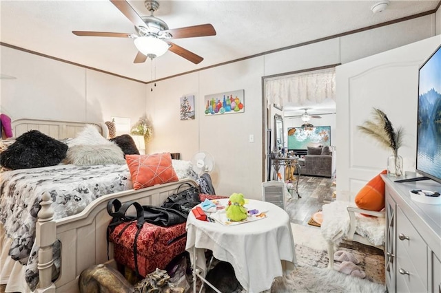 bedroom featuring crown molding, ceiling fan, and hardwood / wood-style floors