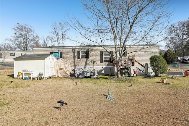 back of house featuring a storage unit and a lawn