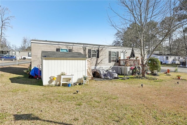 back of property featuring a wooden deck and a yard