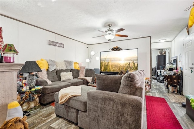 living room featuring crown molding, ceiling fan, and wood-type flooring