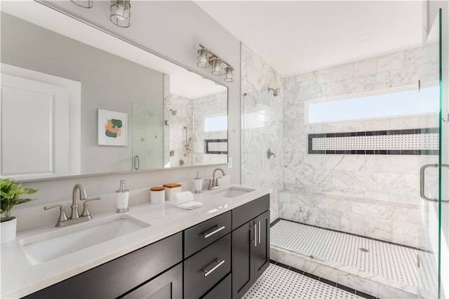 bathroom with a stall shower, double vanity, and a sink