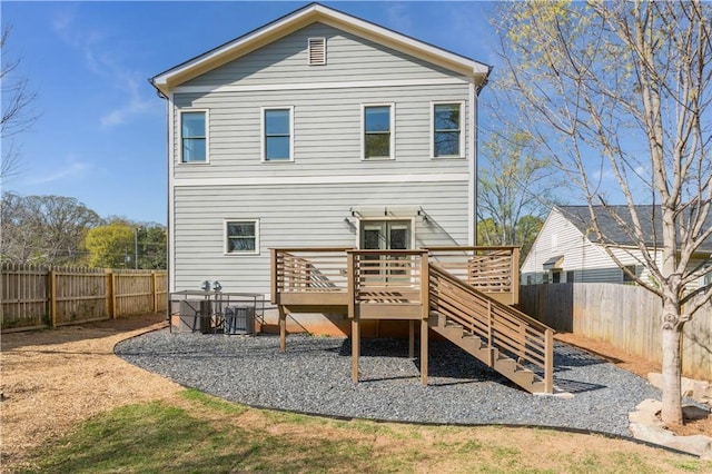 rear view of property with a fenced backyard and a deck