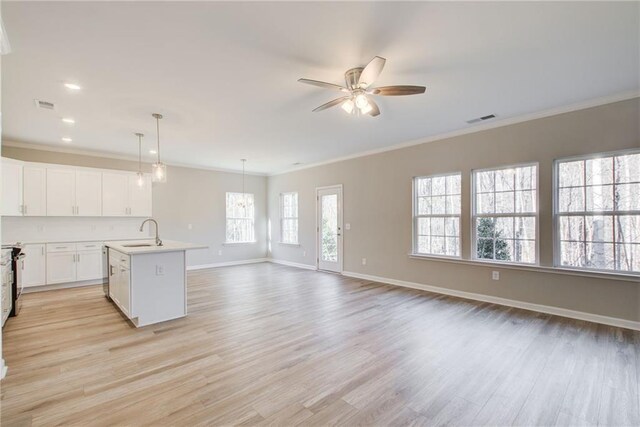 93 Portico Pl, Newnan, GA 30265 - kitchen featuring a ceiling fan, crown molding, light wood finished floors, open floor plan, and an island with sink