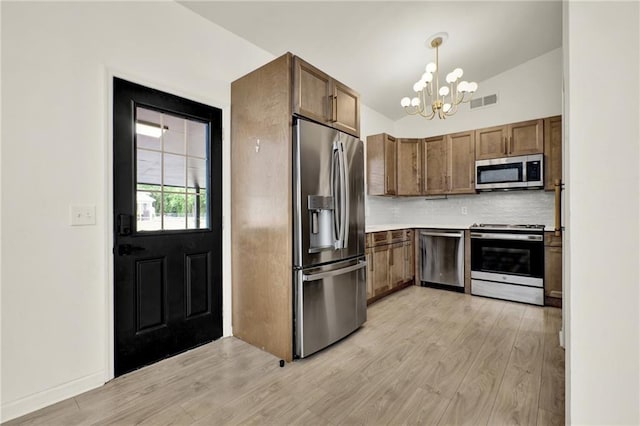 215 Maplewood Dr SW, Calhoun, GA 30701 - kitchen featuring stainless steel appliances, a chandelier, backsplash, light wood-style flooring, and light countertops